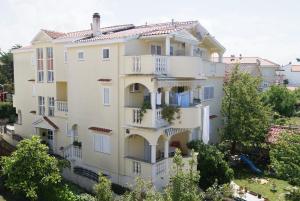 un immeuble d'appartements avec balcon et arbres dans l'établissement Apartments Marta - Zadar, à Zadar
