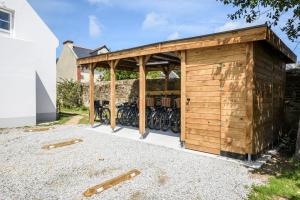 a wooden shed with a bunch of bikes in it at Hotel Le Clos Fleuri in Le Palais