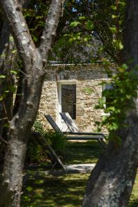 two lounge chairs in front of a stone building at Hotel Le Clos Fleuri in Le Palais