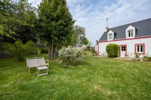 a white chair sitting in the yard of a house at Hotel Le Clos Fleuri in Le Palais