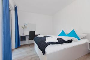 a bedroom with a bed with blue curtains and a desk at Spreepolis Boardinghaus in Berlin