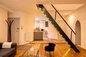 a living room with a couch and a staircase at Chouet'appart in Dijon