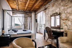 sypialnia z łóżkiem w pokoju z kamienną ścianą w obiekcie Villa Allure of Dubrovnik w Dubrowniku