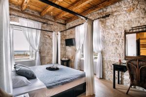 sypialnia z łóżkiem w pokoju z kamienną ścianą w obiekcie Villa Allure of Dubrovnik w Dubrowniku +37 zdjęć