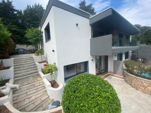 une maison blanche avec un toit noir dans l'établissement Villa de Charme La Lionne-Piscine-12 pers, à Saint-Raphaël