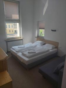 a bedroom with a bed and two windows at OperaHostel in Bydgoszcz