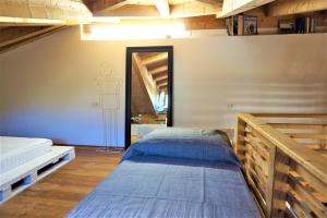 1 dormitorio con 2 camas y espejo en La casa di Claudia, en Arco
