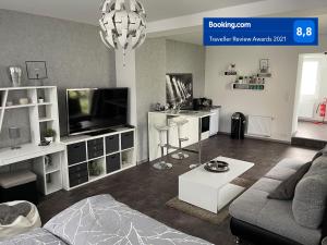 a living room with a couch and a tv at W1 - Kontaktloser 24h CHECK IN, W-LAN, Netflix, Parkplatz, Küche, Boxspring-Bett in Bückeburg