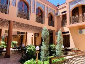 cortile di un edificio con tavoli e sedie di Rangrez Hotel a Bukhara