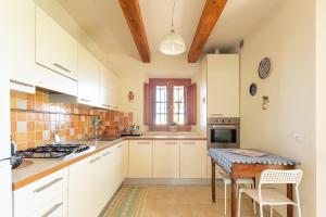 eine Küche mit weißen Schränken und einem Holztisch in der Unterkunft Casa Carlotta in Rimini