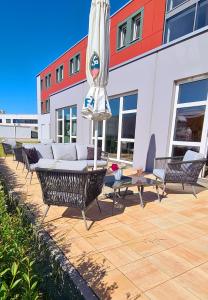 eine Terrasse mit einem Sonnenschirm, Stühlen und einem Tisch in der Unterkunft Euro Hotel Friedberg in Friedberg