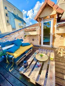 un patio avec un canapé et une table sur une terrasse dans l'établissement Superbe LOFT centre-ville - Sauna - parking privé -Clim- 1 à 10personnes, à Brive-la-Gaillarde