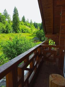 a wooden balcony with a view of a field at Приватна Садиба Потічок in Slavske