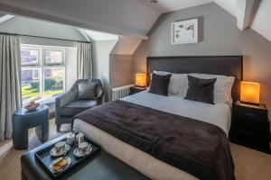 a hotel room with a bed and a chair at Penrhiw Priory in St. Davids