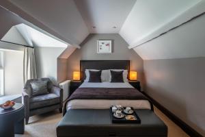 a bedroom with a large bed and a chair at Penrhiw Priory in St. Davids