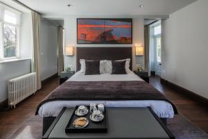 a bedroom with a large bed with a tray of food at Penrhiw Priory in St. Davids