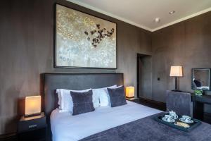 a bedroom with a bed and two lamps and a painting at Penrhiw Priory in St. Davids