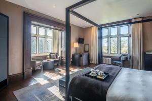 a bedroom with a large bed and a living room at Penrhiw Priory in St. Davids