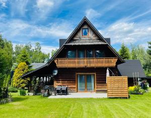 a log cabin with a gambrel roof at Chata Leona in Gorlice