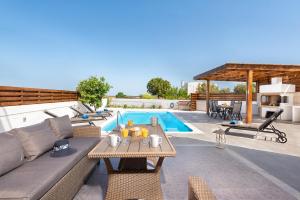 a patio with a couch and a table next to a pool at Ritas Gennadi Villa in Gennadi