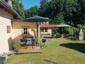 a backyard with a table and an umbrella at Villa Irbe in Jūrmala