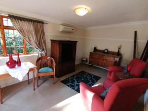 ein Wohnzimmer mit einem roten Sofa und einem Tisch in der Unterkunft Casa Romana B&B in Ladybrand