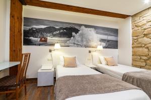 pokój hotelowy z 2 łóżkami i obrazem na ścianie w obiekcie Pension Aida w mieście San Sebastián