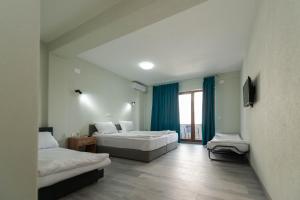 a hotel room with two beds and a window at Villa Aria in Ohrid