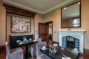 a dining room with a table and a fireplace at Penrhiw Priory in St. Davids