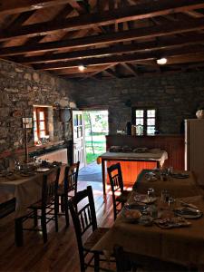 a dining room with tables and chairs and a kitchen at Konaki Hotel in Papigko