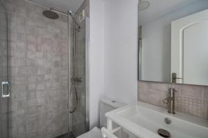 une salle de bain blanche avec une douche et un lavabo dans l'établissement Barrosa Frente al Mar, à Chiclana de la Frontera 10 autres photos