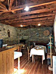 a restaurant with tables and chairs in a room with wooden ceilings at Κονάκι in Papingo +9 photos