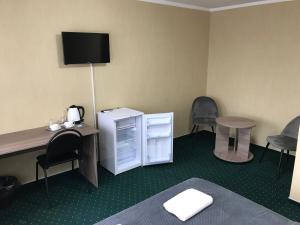um quarto com uma secretária, uma mesa e cadeiras em Guest House RELAX PALANGA em Palanga