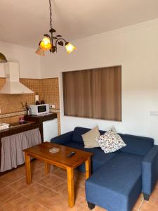 a living room with a blue couch and a table at Apartahotel 4 vientos in Prado del Rey