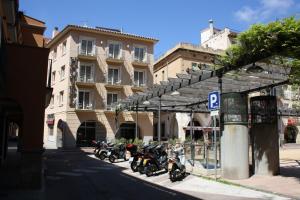 un groupe de motocycles garés devant un bâtiment dans l'établissement Hotel Plaça, à Sant Feliu de Guíxols
