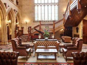 eine Lobby mit Sofas und einem Tisch in einem Gebäude in der Unterkunft Matfen Hall Hotel, Golf & Spa in Matfen