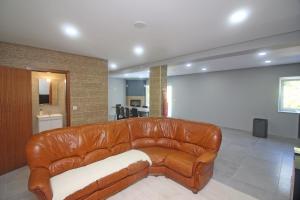 un sofá de cuero marrón en la sala de estar en Casa Ferreira, en Terras de Bouro