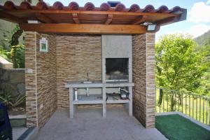 a brick patio with a table under a wooden pergola at Casa Ferreira in Terras de Bouro
