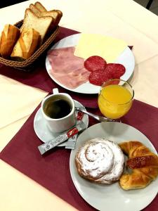 a table with two plates of food and a cup of coffee at Hostal Vila del Mar in Lloret de Mar