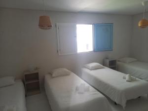 タリファにあるHabitaciones La Vegaの白い部屋で、ベッド2台、窓が備わります。