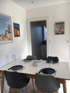 mesa de comedor con 4 sillas y mesa blanca en Beautiful Apartment With Garden, en Cabourg
