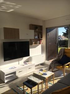 sala de estar con TV de pantalla plana grande en Beautiful Apartment With Garden, en Cabourg