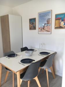 una mesa con sillas y una mesa blanca con platos. en Beautiful Apartment With Garden, en Cabourg