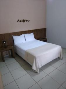 A bed or beds in a room at Pousada Vila Cocais
