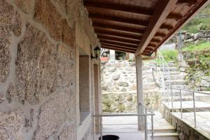 un bâtiment avec un mur en pierre et un escalier dans l'établissement Casa Joao Vilar, à Campo do Gerês