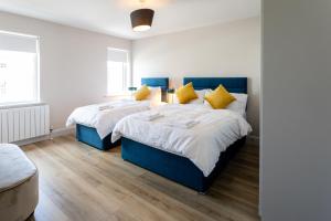 two beds in a room with white and blue at Hilltown Lodges No5 in Hilltown