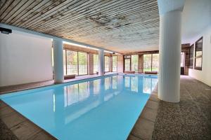 a large swimming pool with blue water in a building at APPARTEMENT ST JEAN D'AULPS - PROCHE PIED DES PISTES - PROCHE MORZINE - Riam 6 in Saint-Jean-d'Aulps
