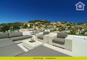 un patio con sofás y sillas y vistas a la ciudad en Solhabitat Sport, en Moraira