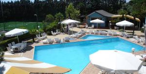 une grande piscine bleue avec des chaises et des parasols dans l'établissement Risthotel Airport, à Fogliano Redipúglia