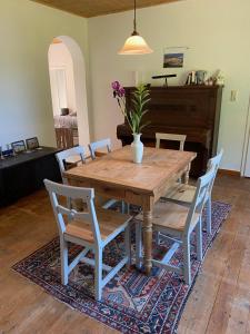 a dining room table with chairs and a piano at Landhaus Viezer Mühle in Viez